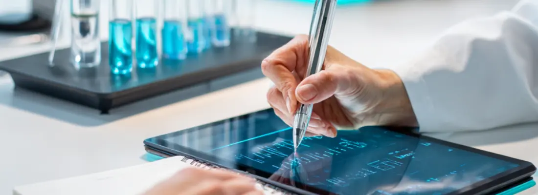 Profesional de laboratorio analizando datos en una tablet junto a muestras de ensayo