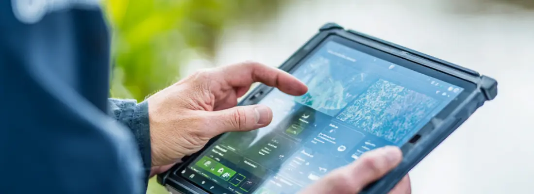 Sampling technician checking the LIMS on a rugged tablet during fieldwork